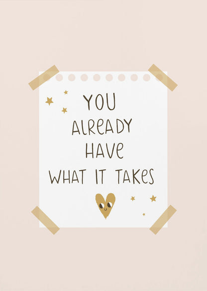 A motivational poster in a black frame with a pale pink background. A white piece of notebook paper is taped to the center with the handwritten text 'YOU ALREADY HAVE WHAT IT TAKES' in brown. It's decorated with small gold stars and a cute, smiling gold heart. Decor