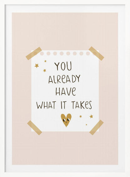 A motivational poster in a black frame with a pale pink background. A white piece of notebook paper is taped to the center with the handwritten text 'YOU ALREADY HAVE WHAT IT TAKES' in brown. It's decorated with small gold stars and a cute, smiling gold heart. Decor