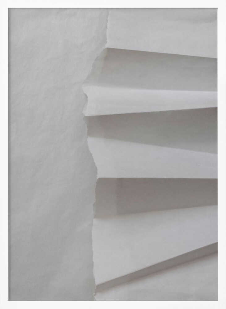 A minimalist composition of folded and torn white paper, showcasing geometric forms and shadows in a black frame.