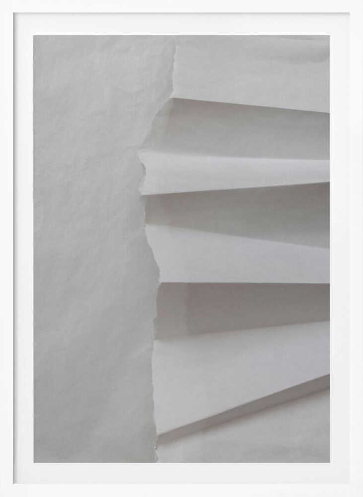 A minimalist composition of folded and torn white paper, showcasing geometric forms and shadows in a black frame.