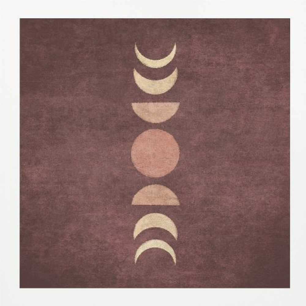 A minimalist piece of framed art showing the phases of the moon arranged vertically against a textured, deep maroon background. The moon shapes are colored in shades of cream and dusty rose, with the full moon in the center. Print