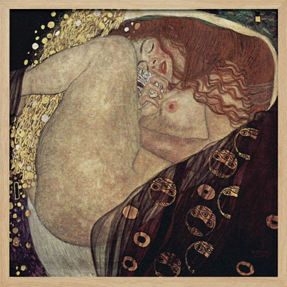 A print of Gustav Klimt's 1907 painting, 'Danaë'. The artwork depicts a sleeping, nude woman with vibrant red hair curled into a fetal position, receiving a shower of golden rain. The style is characteristic of Art Nouveau, with rich, decorative patterns on surrounding fabrics against a dark, star-like background, all within a light wood frame. Wall Art
