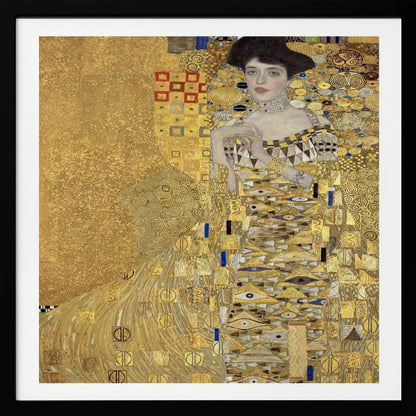 A framed print of Gustav Klimt's 'Portrait of Adele Bloch-Bauer I,' also known as 'The Woman in Gold.' The painting depicts a woman in an ornate, gilded gown covered in intricate patterns, blending into a shimmering gold background characteristic of the Art Nouveau style. Poster