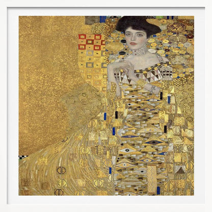 A framed print of Gustav Klimt's 'Portrait of Adele Bloch-Bauer I,' also known as 'The Woman in Gold.' The painting depicts a woman in an ornate, gilded gown covered in intricate patterns, blending into a shimmering gold background characteristic of the Art Nouveau style. Poster
