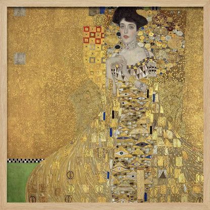A framed print of Gustav Klimt's 'Portrait of Adele Bloch-Bauer I,' also known as 'The Woman in Gold.' The painting depicts a woman in an ornate, gilded gown covered in intricate patterns, blending into a shimmering gold background characteristic of the Art Nouveau style. Poster
