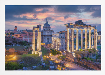 A scenic photograph of the ancient Roman Forum in Rome, Italy, at dusk. The ruins, including prominent columns and arches, are illuminated by warm lights, contrasting with the deep blue and vibrant pink of the sunset sky. Wall Art