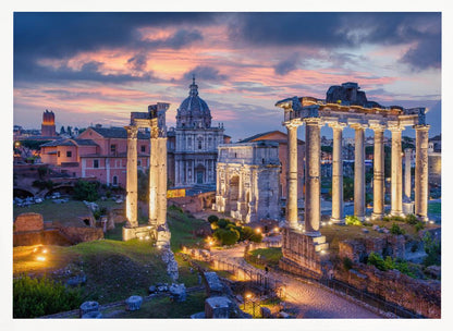 A scenic photograph of the ancient Roman Forum in Rome, Italy, at dusk. The ruins, including prominent columns and arches, are illuminated by warm lights, contrasting with the deep blue and vibrant pink of the sunset sky. Wall Art