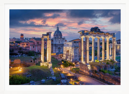 A scenic photograph of the ancient Roman Forum in Rome, Italy, at dusk. The ruins, including prominent columns and arches, are illuminated by warm lights, contrasting with the deep blue and vibrant pink of the sunset sky. Wall Art