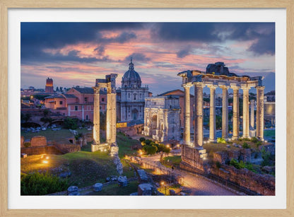 A scenic photograph of the ancient Roman Forum in Rome, Italy, at dusk. The ruins, including prominent columns and arches, are illuminated by warm lights, contrasting with the deep blue and vibrant pink of the sunset sky. Wall Art