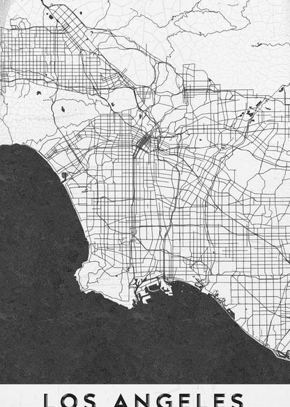 A minimalist black and white framed poster of a street map of Los Angeles. The land is white with an intricate grid of black lines representing roads and highways, while the Pacific Ocean is a solid, textured black. A white band at the bottom contains the city's name, 'LOS ANGELES', in a bold, black sans-serif font. Decor