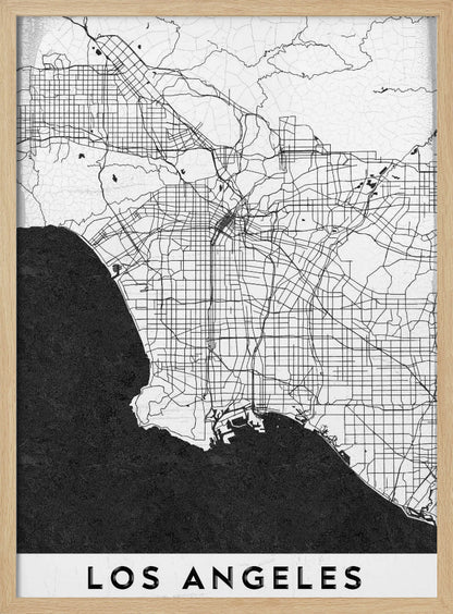 A minimalist black and white framed poster of a street map of Los Angeles. The land is white with an intricate grid of black lines representing roads and highways, while the Pacific Ocean is a solid, textured black. A white band at the bottom contains the city's name, 'LOS ANGELES', in a bold, black sans-serif font. Decor