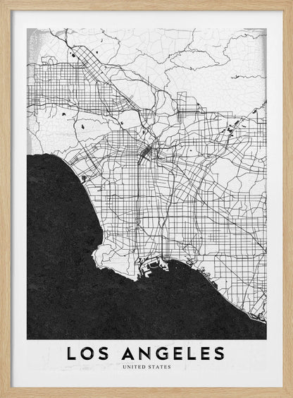 A minimalist black and white framed poster of a street map of Los Angeles. The land is white with an intricate grid of black lines representing roads and highways, while the Pacific Ocean is a solid, textured black. A white band at the bottom contains the city's name, 'LOS ANGELES', in a bold, black sans-serif font. Decor