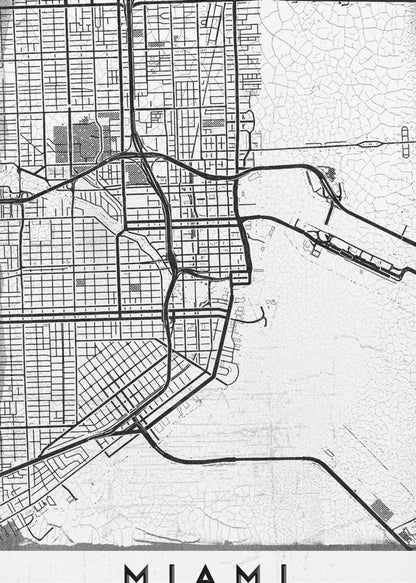 A minimalist black and white street map of Miami, Florida, with a distressed, textured background. The map is framed in black with the word 'MIAMI' printed in bold capital letters at the bottom. Artwork