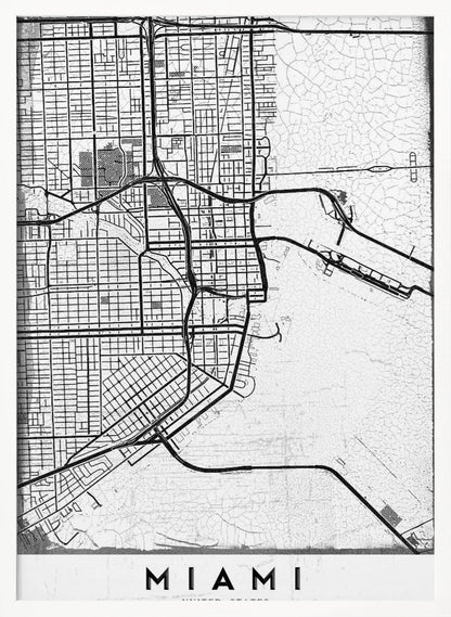 A minimalist black and white street map of Miami, Florida, with a distressed, textured background. The map is framed in black with the word 'MIAMI' printed in bold capital letters at the bottom. Artwork