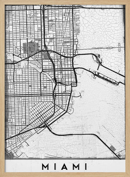 A minimalist black and white street map of Miami, Florida, with a distressed, textured background. The map is framed in black with the word 'MIAMI' printed in bold capital letters at the bottom. Artwork