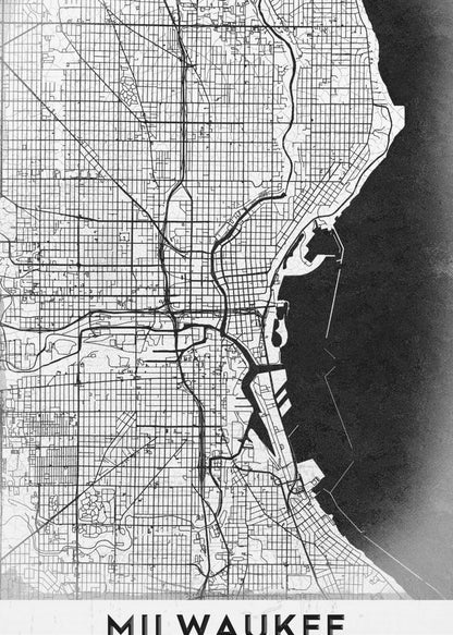 A minimalist, black and white street map of Milwaukee, displayed in a black frame. The map details the city's grid system, major roads, and waterways against a textured background, with the word 'MILWAUKEE' in a bold, sans-serif font at the bottom. Poster