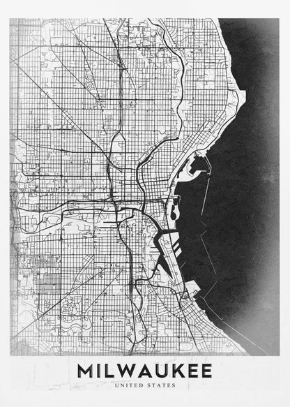 A minimalist, black and white street map of Milwaukee, displayed in a black frame. The map details the city's grid system, major roads, and waterways against a textured background, with the word 'MILWAUKEE' in a bold, sans-serif font at the bottom. Poster