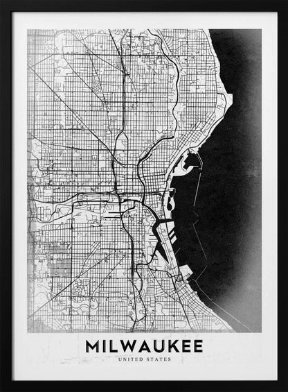 A minimalist, black and white street map of Milwaukee, displayed in a black frame. The map details the city's grid system, major roads, and waterways against a textured background, with the word 'MILWAUKEE' in a bold, sans-serif font at the bottom. Poster