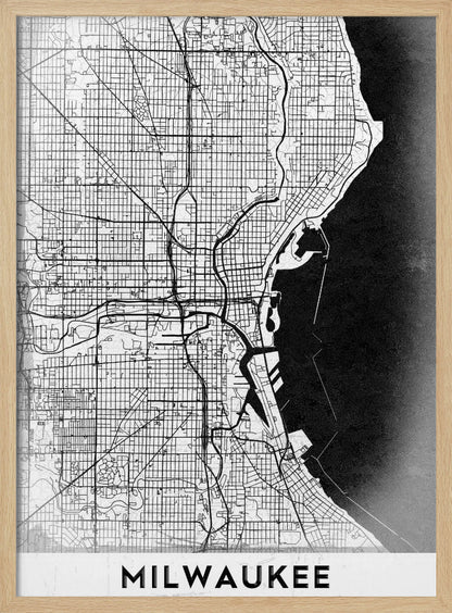 A minimalist, black and white street map of Milwaukee, displayed in a black frame. The map details the city's grid system, major roads, and waterways against a textured background, with the word 'MILWAUKEE' in a bold, sans-serif font at the bottom. Poster