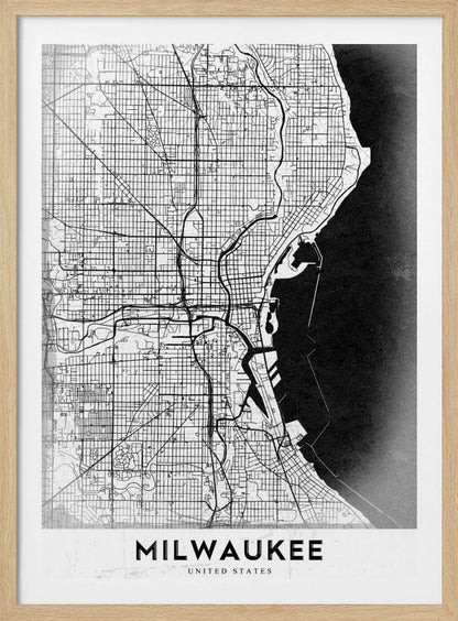 A minimalist, black and white street map of Milwaukee, displayed in a black frame. The map details the city's grid system, major roads, and waterways against a textured background, with the word 'MILWAUKEE' in a bold, sans-serif font at the bottom. Poster