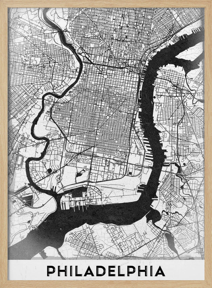 A modern black and white framed poster of a city map of Philadelphia. The map details the street grid, with the Schuylkill and Delaware rivers prominently featured in solid black. The word 'PHILADELPHIA' is printed in a bold, black sans-serif font at the bottom. Artwork