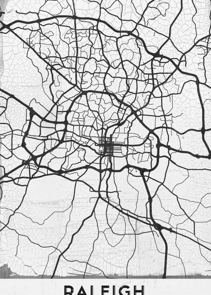 A minimalist black and white street map of Raleigh, North Carolina, displayed in a black frame. The map features black lines representing roads on a distressed, crackled white background. At the bottom, the word 'RALEIGH' is printed in a bold, black, sans-serif font. Print