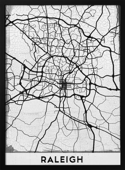 A minimalist black and white street map of Raleigh, North Carolina, displayed in a black frame. The map features black lines representing roads on a distressed, crackled white background. At the bottom, the word 'RALEIGH' is printed in a bold, black, sans-serif font. Print