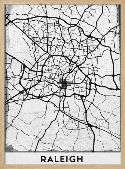 A minimalist black and white street map of Raleigh, North Carolina, displayed in a black frame. The map features black lines representing roads on a distressed, crackled white background. At the bottom, the word 'RALEIGH' is printed in a bold, black, sans-serif font. Print