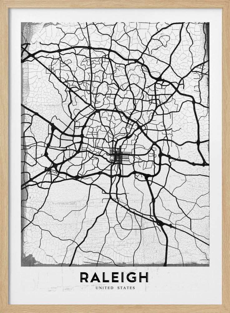 A minimalist black and white street map of Raleigh, North Carolina, displayed in a black frame. The map features black lines representing roads on a distressed, crackled white background. At the bottom, the word 'RALEIGH' is printed in a bold, black, sans-serif font. Print