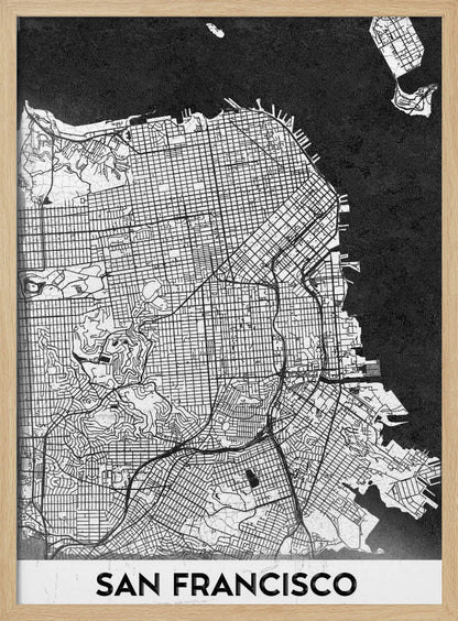 A minimalist black and white art print of a San Francisco city map. The street grid and landmass are depicted in white with fine black lines, set against a solid black background representing the water. A black frame surrounds the map, and a white banner at the bottom displays the text 'SAN FRANCISCO' in a bold, black font. Wall Art