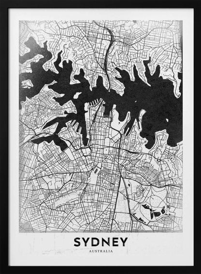A modern black and white framed art print of a city map of Sydney, Australia. The water bodies are shown in solid textured black, while the land is depicted with a detailed white street grid. At the bottom, the word 'SYDNEY' is printed in bold capital letters. Poster