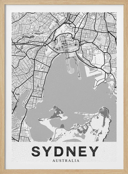 A modern, black and white framed art print of a stylized map of Sydney, Australia. The map features bold black lines for the street grid and major roads, with light grey for the landmass and a darker grey for the water of the harbor. The word 'SYDNEY' is printed in large, black, sans-serif font at the bottom of the poster. Poster