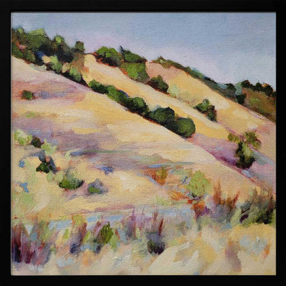 An impressionist oil painting of golden, rolling hills dotted with green shrubs under a pale blue sky, framed in light wood.