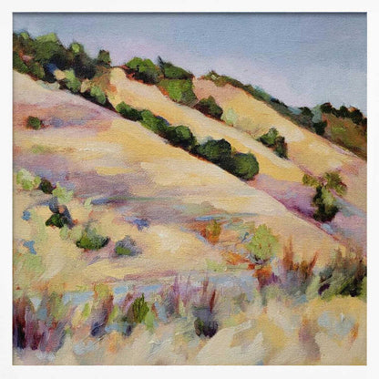 An impressionist oil painting of golden, rolling hills dotted with green shrubs under a pale blue sky, framed in light wood.
