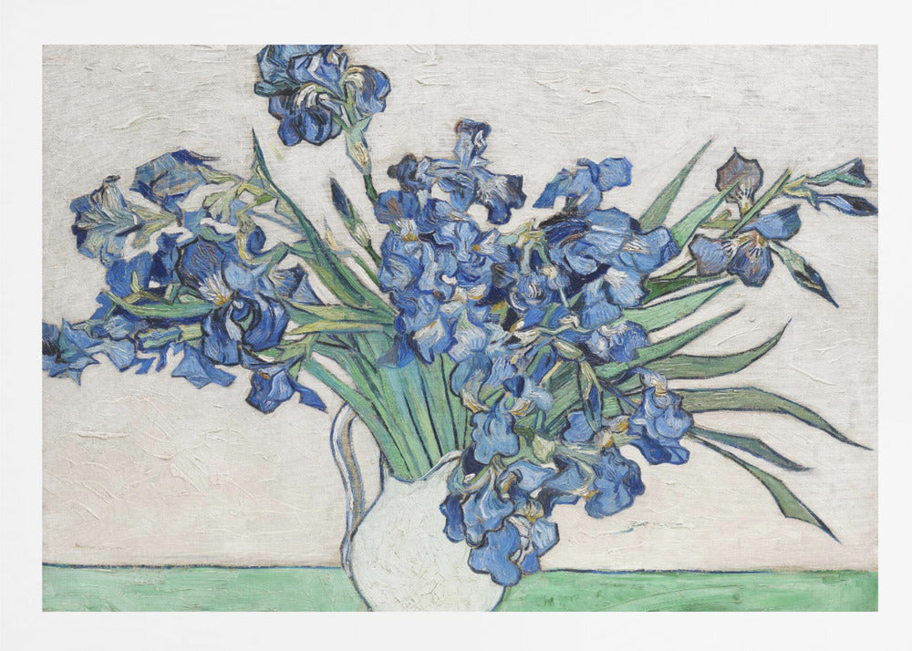 A framed print of Vincent van Gogh's famous painting 'Irises'. It features a large bouquet of vibrant blue iris flowers with long green leaves, arranged in a simple white pitcher. The background is a textured off-white wall, and the pitcher rests on a light green surface. The painting is in the post-impressionist style with thick, visible brushstrokes. Wall Art