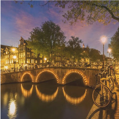 An idyllic nightscape view of Keizersgracht canal in Amsterdam, featuring illuminated buildings reflecting on the water under a dark sky. Wall Art