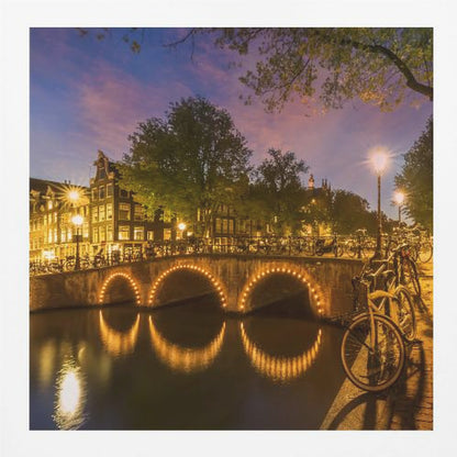 An idyllic nightscape view of Keizersgracht canal in Amsterdam, featuring illuminated buildings reflecting on the water under a dark sky. Wall Art