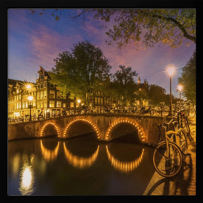 An idyllic nightscape view of Keizersgracht canal in Amsterdam, featuring illuminated buildings reflecting on the water under a dark sky. Wall Art