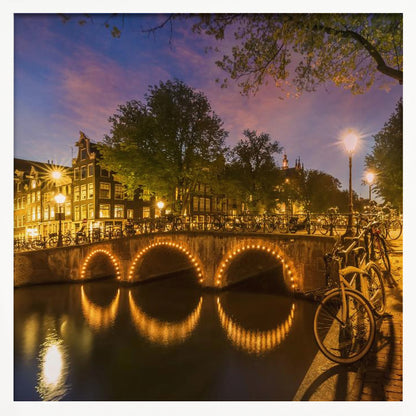 An idyllic nightscape view of Keizersgracht canal in Amsterdam, featuring illuminated buildings reflecting on the water under a dark sky. Wall Art