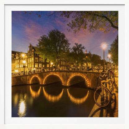 An idyllic nightscape view of Keizersgracht canal in Amsterdam, featuring illuminated buildings reflecting on the water under a dark sky. Wall Art