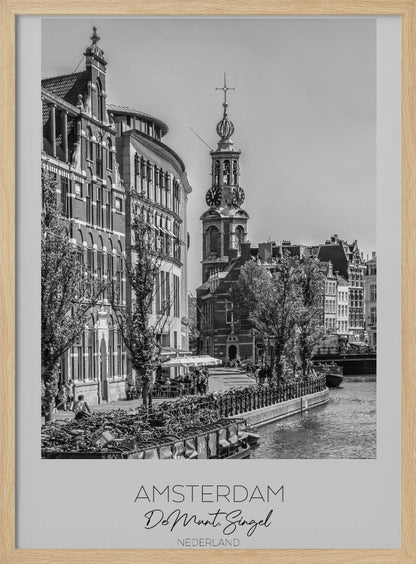 A black and white travel poster of Amsterdam, Netherlands. The photo shows the Munttoren clock tower and traditional Dutch buildings along the Singel canal. A floating barge filled with bicycles is in the foreground. The poster has a white border with the text 'AMSTERDAM', 'De Munt, Singel', and 'NEDERLAND' at the bottom. Artwork
