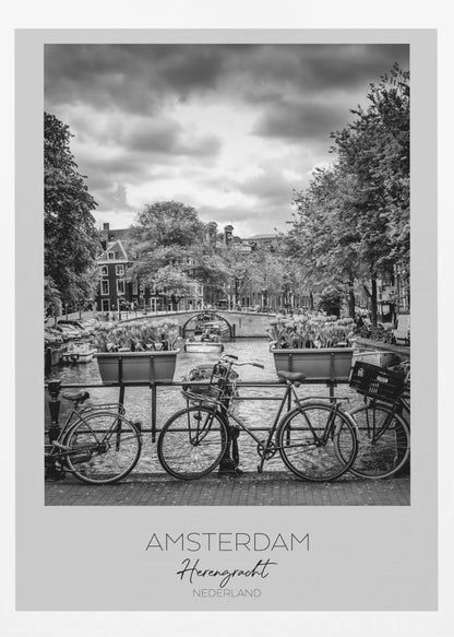 A black and white poster of the Herengracht canal in Amsterdam. In the foreground, two bicycles are parked by a railing with flower boxes. In the background, there's a classic view of the canal with a bridge, canal houses, and boats under a cloudy sky. The bottom of the poster has text that reads 'AMSTERDAM Herengracht NEDERLAND'. Decor