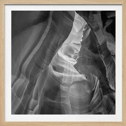 Black and white photo of light in a narrow slot canyon, highlighting smooth, layered rock formations. Nature wall art.