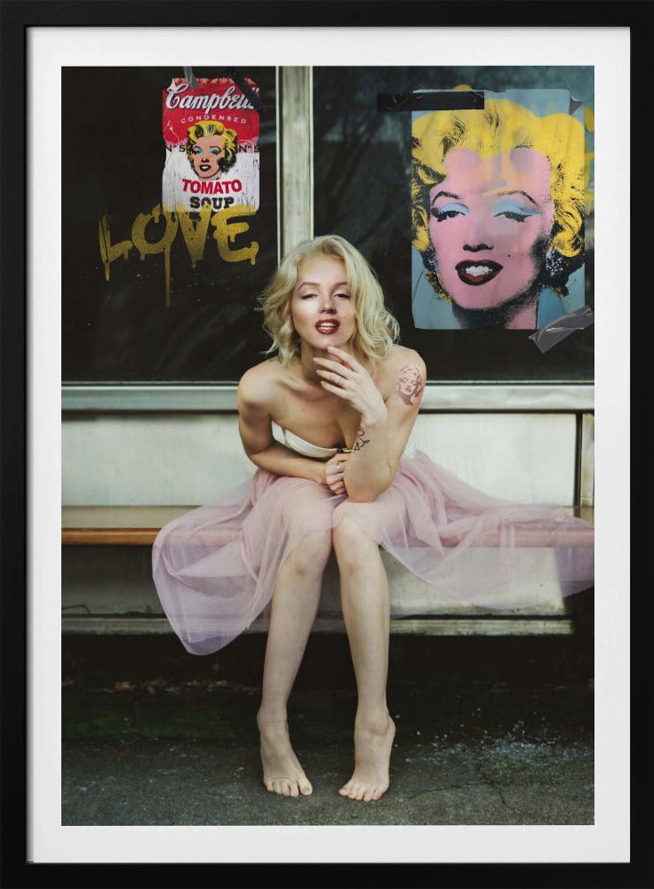 A blonde woman styled like Marilyn Monroe sits on a bench, wearing a pink tulle skirt. Behind her, a dark window features an Andy Warhol-style poster of Monroe, a Campbell's soup can parody, and the word 'LOVE' in gold graffiti. Artwork