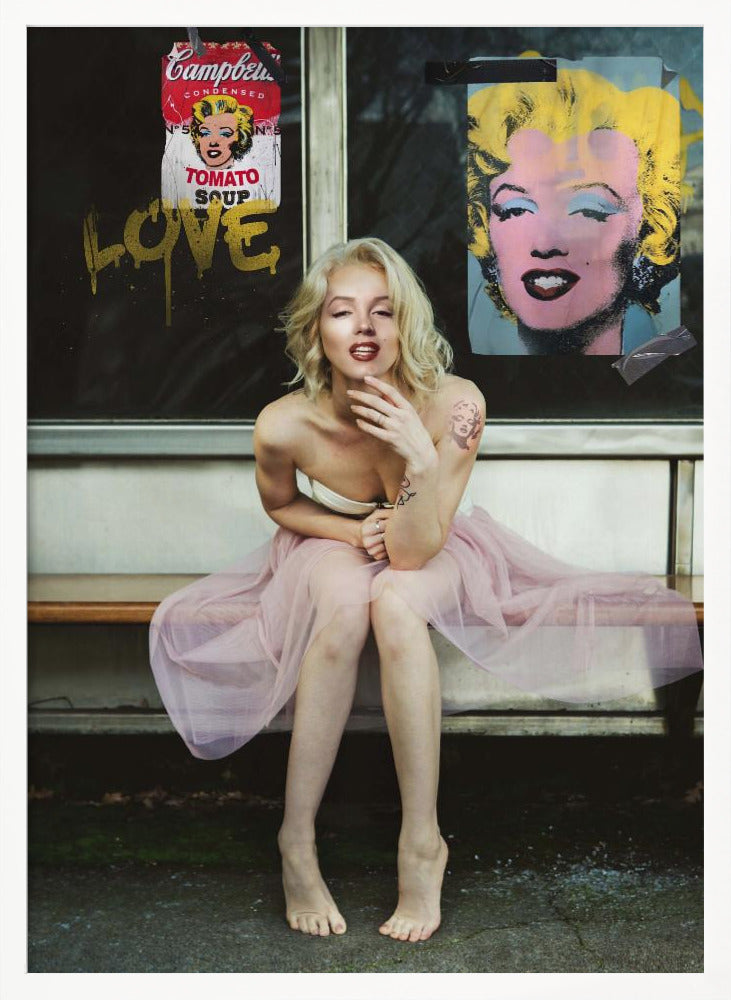 A blonde woman styled like Marilyn Monroe sits on a bench, wearing a pink tulle skirt. Behind her, a dark window features an Andy Warhol-style poster of Monroe, a Campbell's soup can parody, and the word 'LOVE' in gold graffiti. Artwork