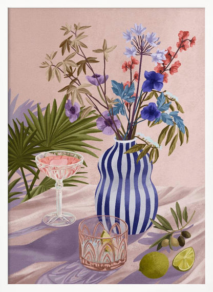 A vibrant still life painting featuring a blue and white striped wavy vase filled with a colorful bouquet of flowers. To the left is a pink cocktail in a coupe glass and a decorative tumbler. In the foreground, there are fresh limes and an olive branch. The scene is set on a draped pink cloth against a soft pink background with shadows from palm leaves. Artwork