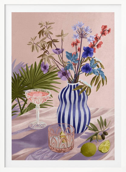 A vibrant still life painting featuring a blue and white striped wavy vase filled with a colorful bouquet of flowers. To the left is a pink cocktail in a coupe glass and a decorative tumbler. In the foreground, there are fresh limes and an olive branch. The scene is set on a draped pink cloth against a soft pink background with shadows from palm leaves. Artwork
