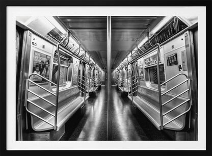 A framed, black and white photograph capturing a perfectly symmetrical view down the aisle of an empty subway car. The reflective, dark floor and the metallic seats and handrails create strong leading lines, giving the image a sense of depth and urban solitude. Wall Art