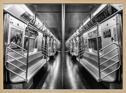 A framed, black and white photograph capturing a perfectly symmetrical view down the aisle of an empty subway car. The reflective, dark floor and the metallic seats and handrails create strong leading lines, giving the image a sense of depth and urban solitude. Wall Art