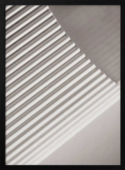 Abstract photograph of a ribbed surface with diagonal lines created by light and shadow, minimalist wall art.